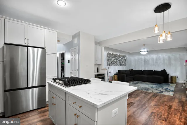 a kitchen with a refrigerator a stove a sink cabinets and wooden floor