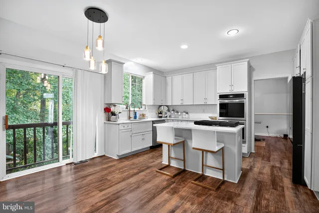 a kitchen with a sink stainless steel appliances and window