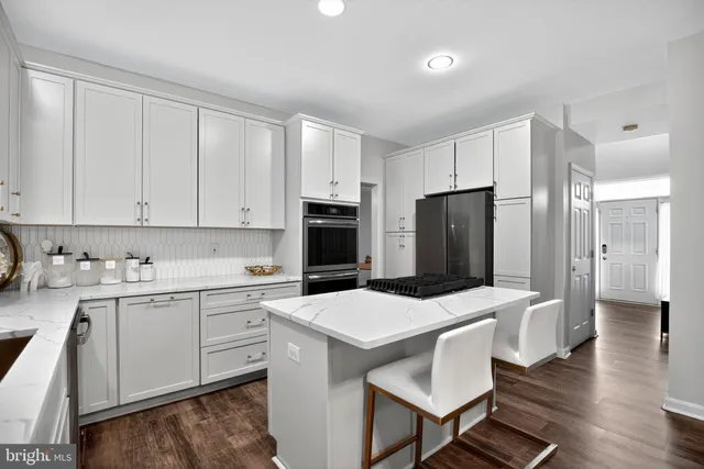 a kitchen with a sink a stove a refrigerator and white cabinets