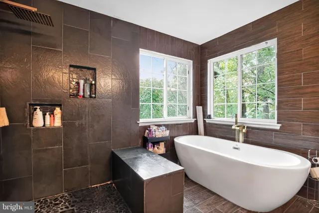 a white bath tub sitting in a bathroom next to a window