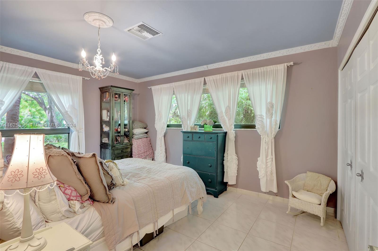 9290 Southwest 117th Terrace Miami, FL 33176 - Photo 15 of 26 a bedroom with a bed chandelier and large window