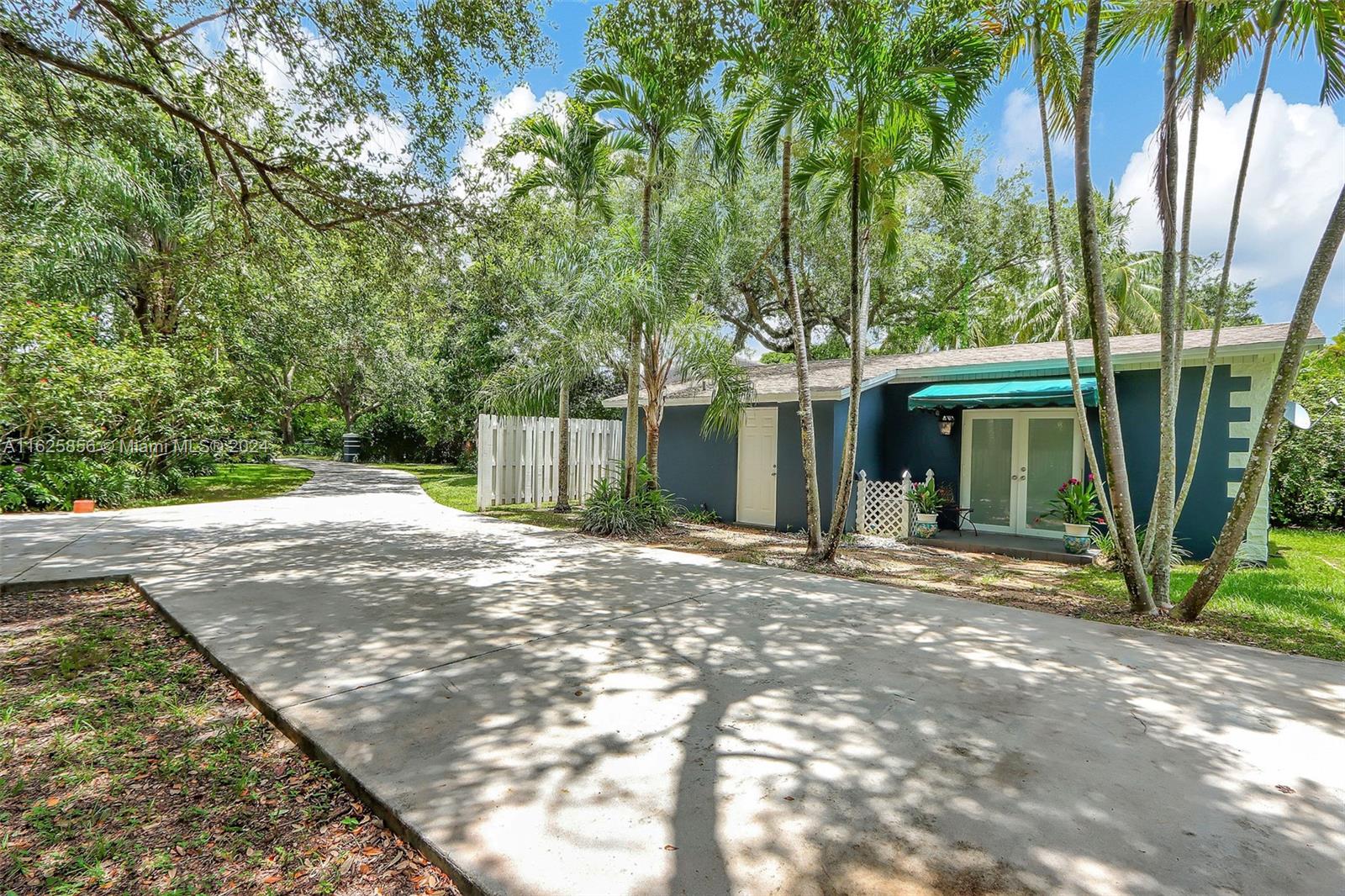 9290 Southwest 117th Terrace Miami, FL 33176 - Photo 20 of 26 a view of a house with a tree and a yard