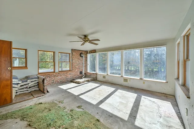 a view of a big room with windows and chandelier fan