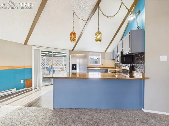 a kitchen with stainless steel appliances granite countertop a refrigerator a stove and a sink with granite countertops