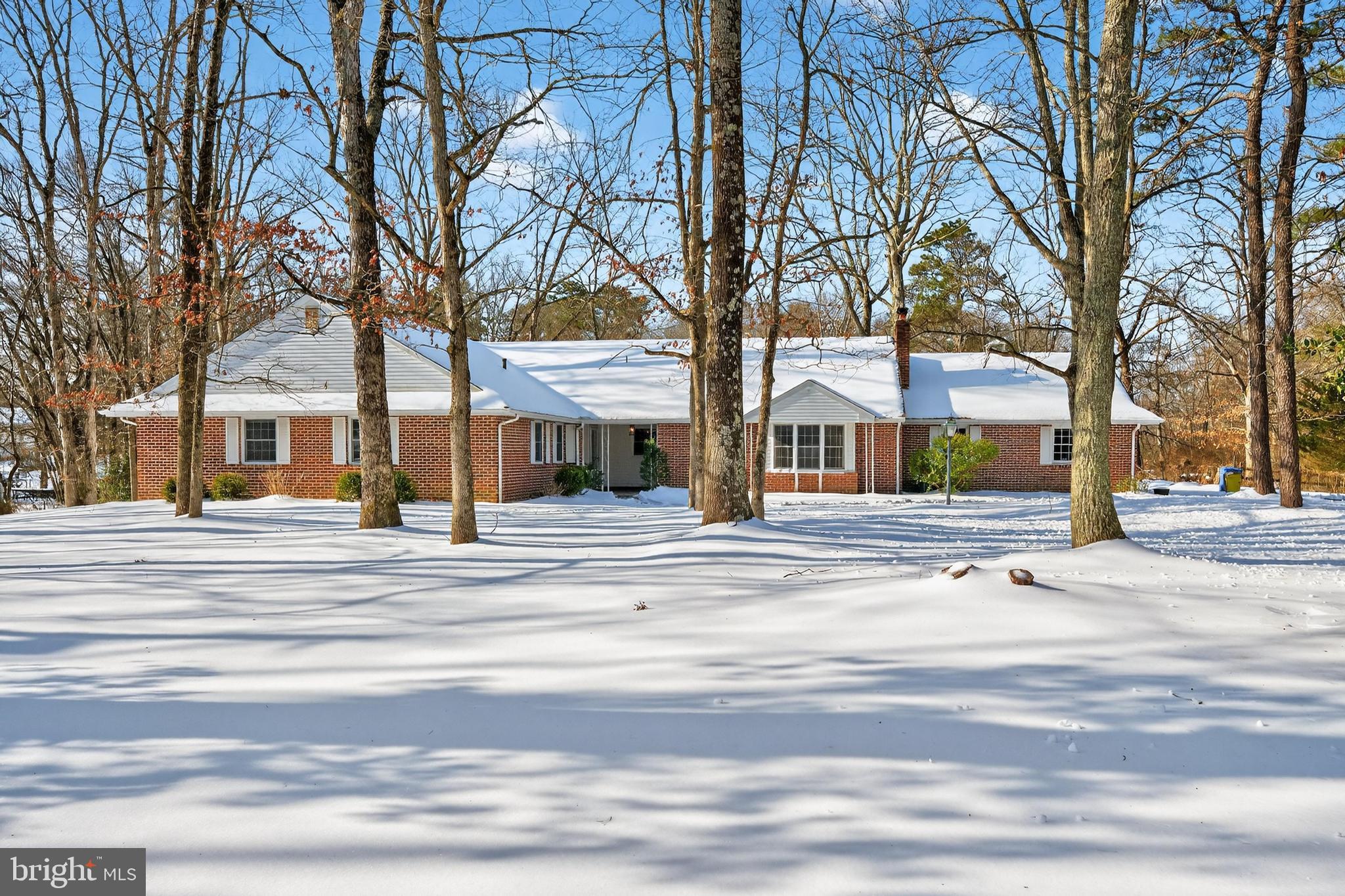 front view of a white house with a large tree