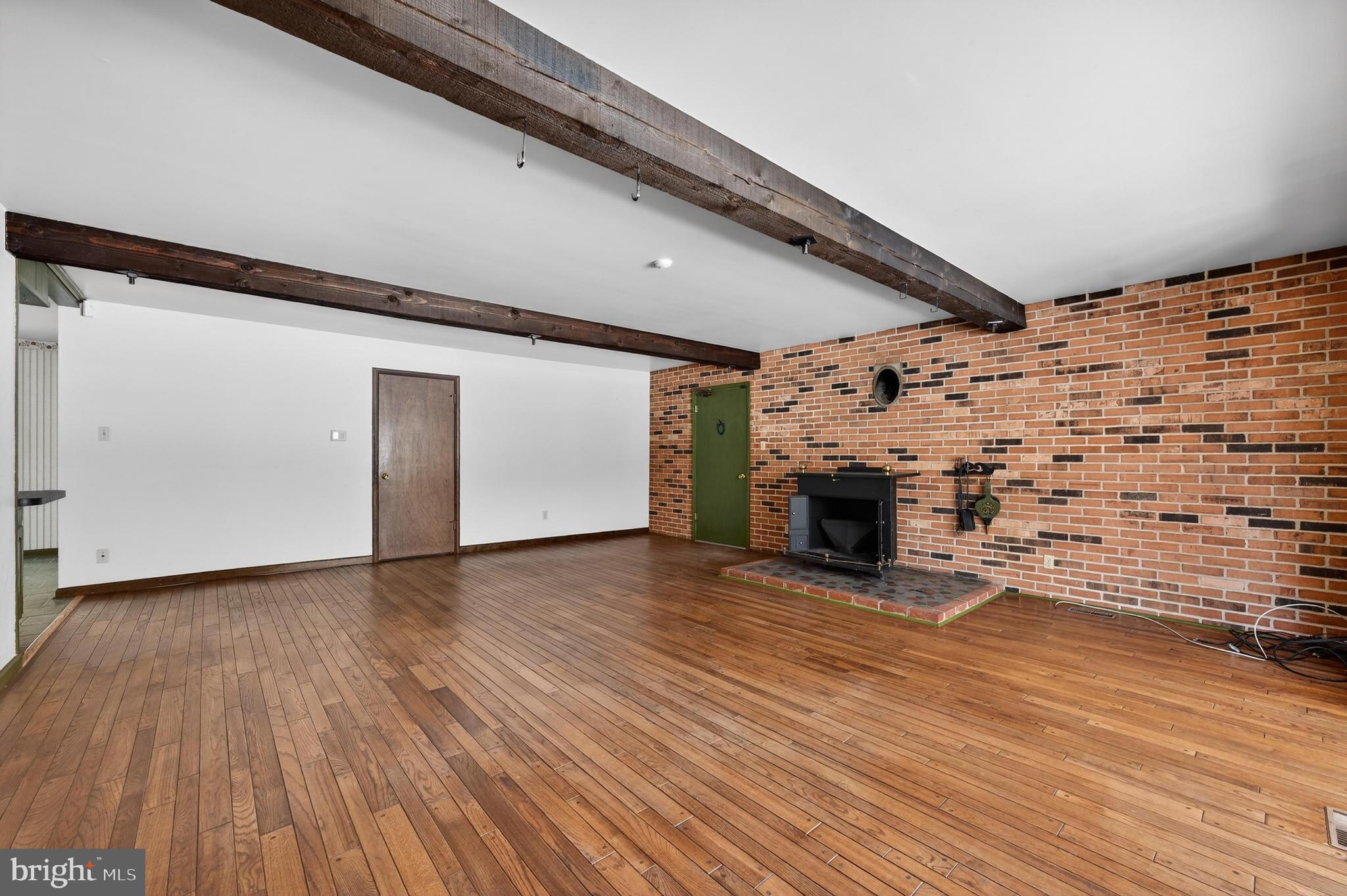 425 Stokes Road Shamong, NJ 08088 - Photo 13 of 35 a view of empty room with wooden floor and fireplace