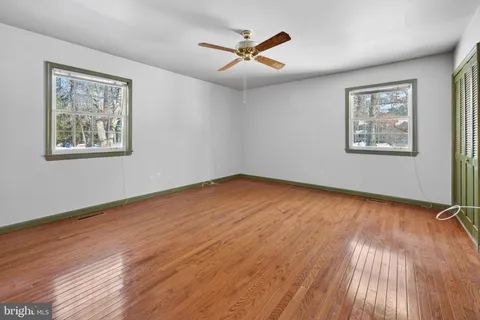 a view of room with wooden floor and ceiling fan