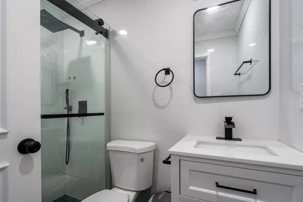 a bathroom with a sink a toilet and a mirror