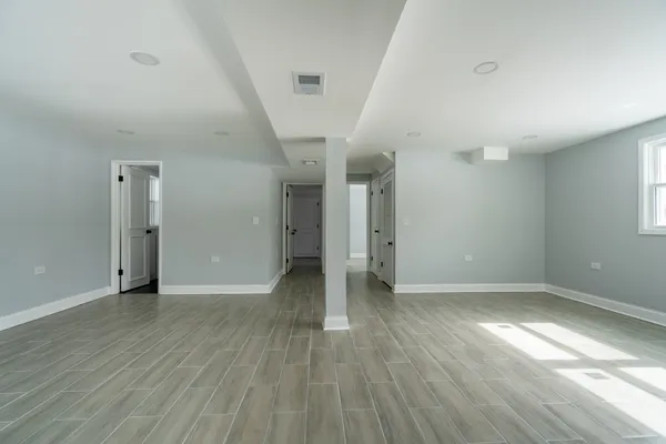 a view of an empty room with wooden floor