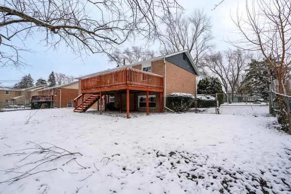 a front view of a house with a yard covered in snow