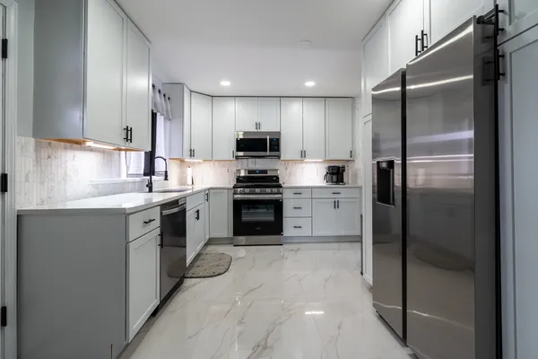 a kitchen with a refrigerator and a stove top oven