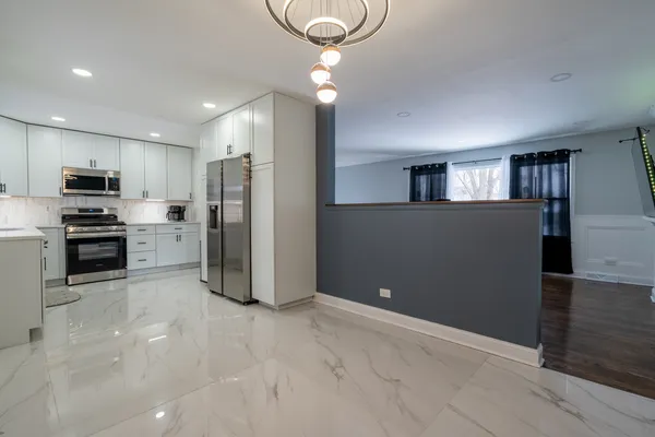 a kitchen with stainless steel appliances granite countertop a refrigerator and a stove top oven