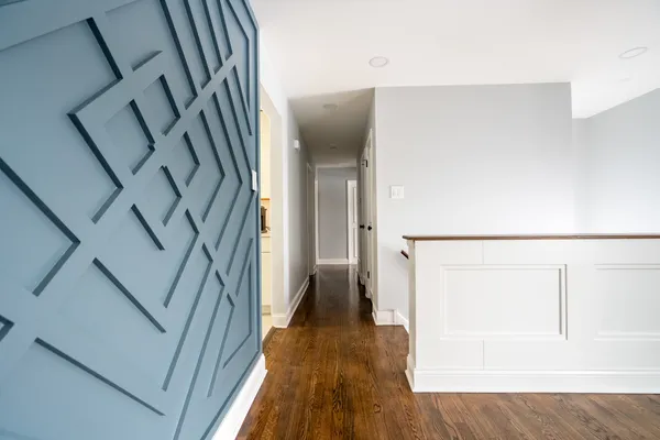 a view of a hallway with wooden floor and staircase
