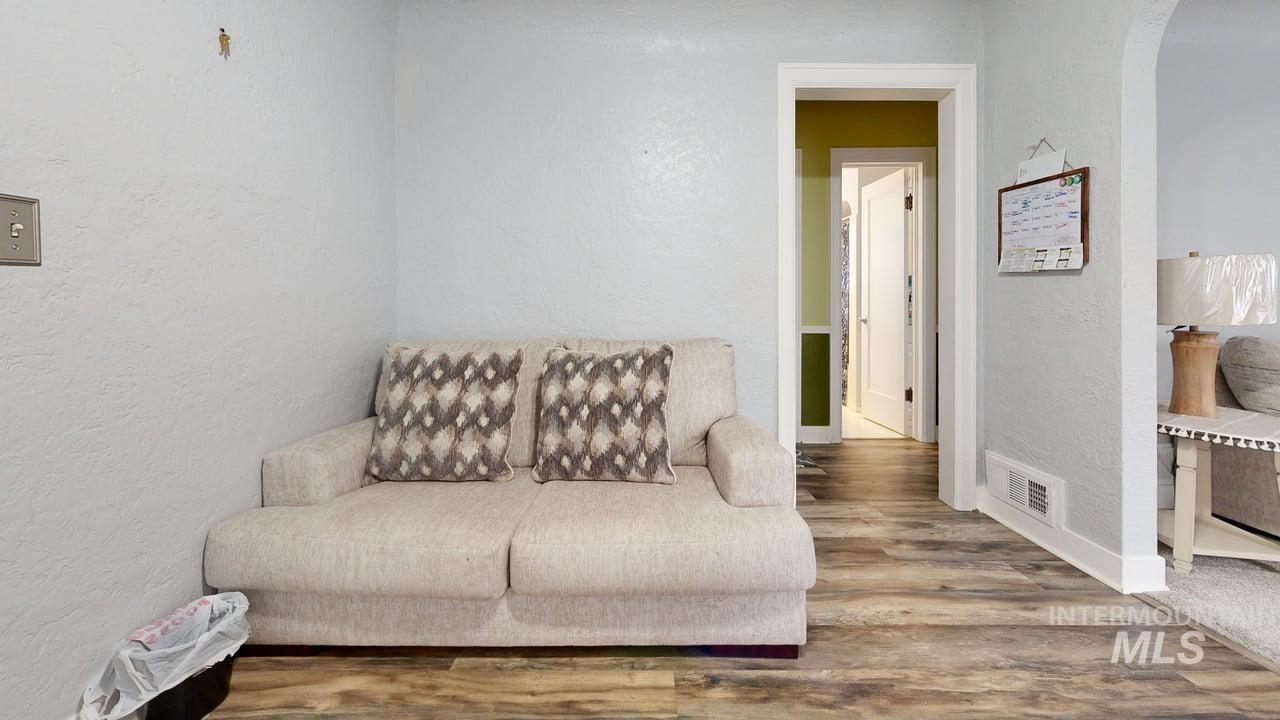 1210 10th Street Lewiston, ID 83501 - Photo 11 of 25 Living area featuring a textured wall, wood finished floors, and arched walkways