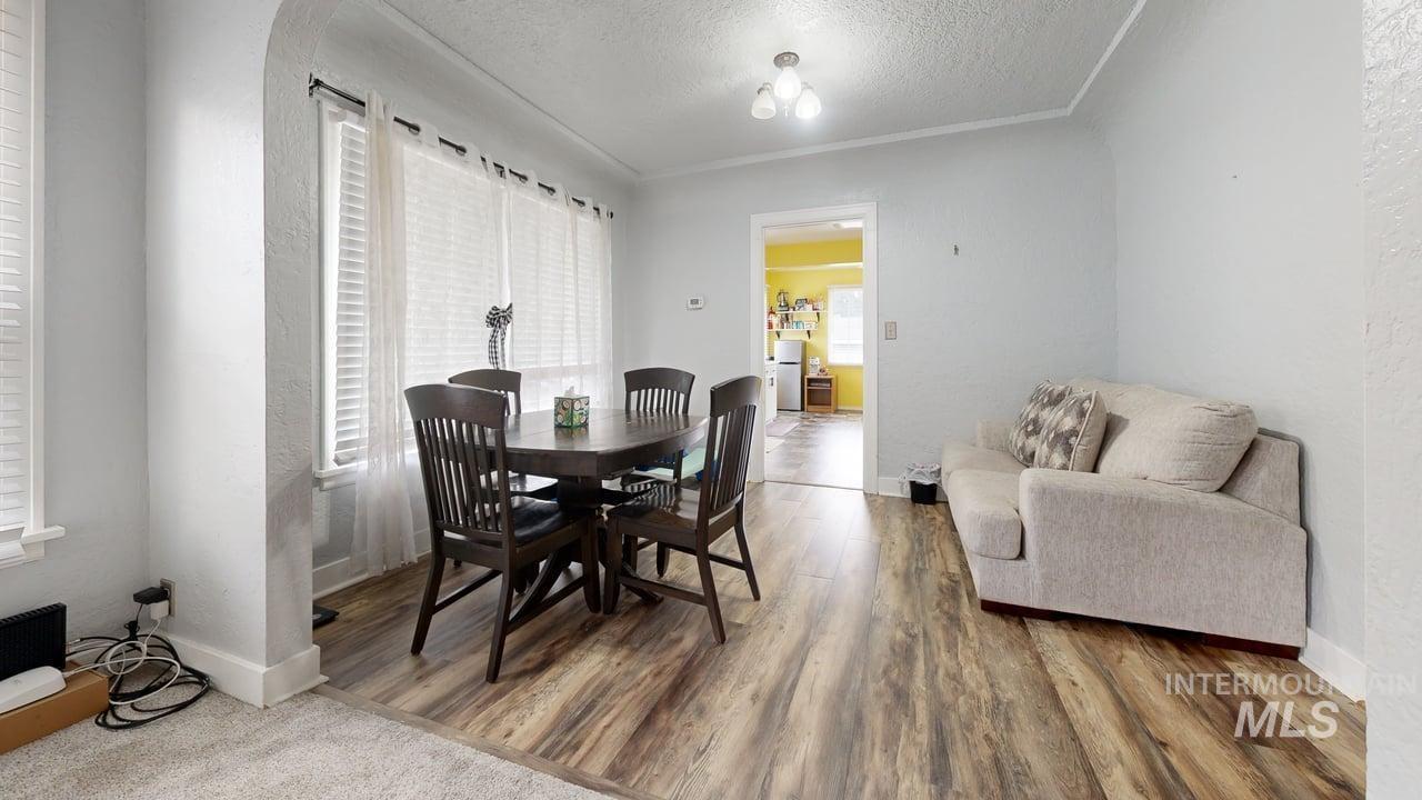 1210 10th Street Lewiston, ID 83501 - Photo 7 of 25 Dining room featuring a textured ceiling, a textured wall, wood finished floors, and crown molding