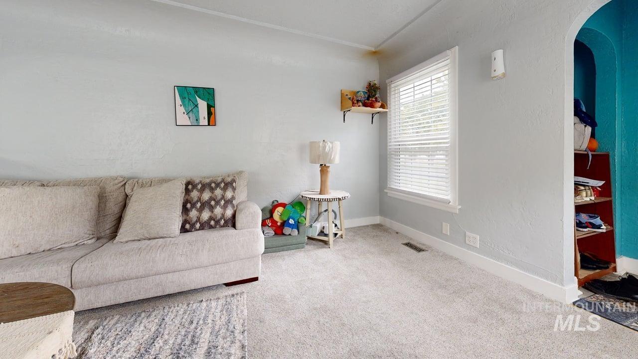 1210 10th Street Lewiston, ID 83501 - Photo 9 of 25 Living area with arched walkways, carpet, and a textured wall