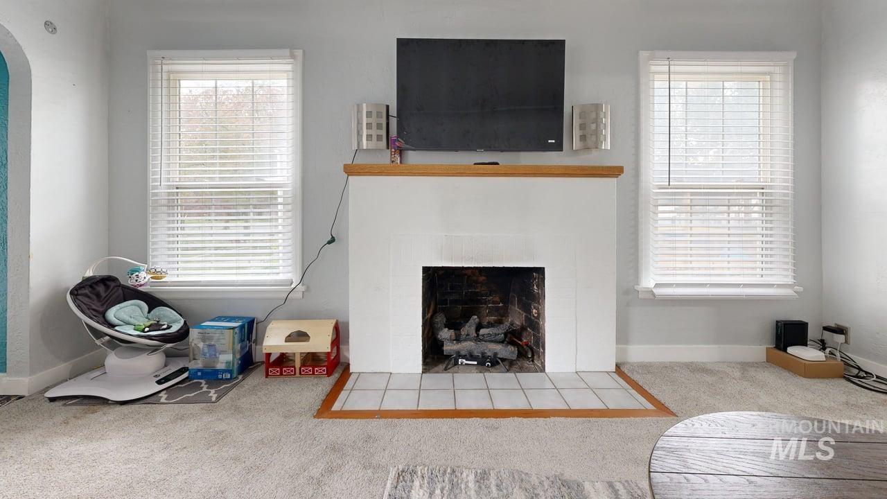 1210 10th Street Lewiston, ID 83501 - Photo 10 of 25 Carpeted living room featuring a fireplace with flush hearth and arched walkways