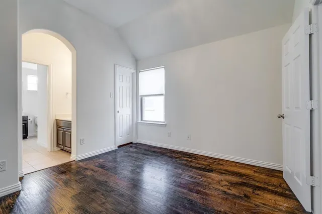 an empty room with wooden floor and a window