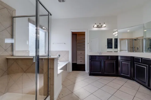 a bathroom with a granite countertop double vanity sink and a mirror