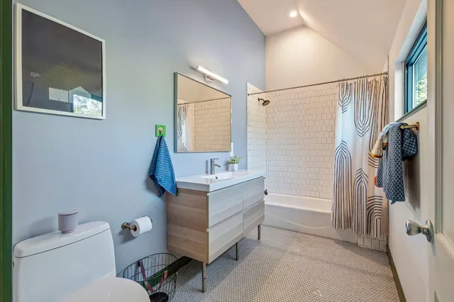 a bathroom with a granite countertop sink toilet and shower