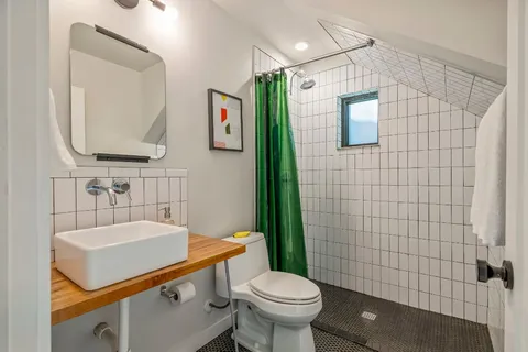 a bathroom with a sink a toilet and mirror