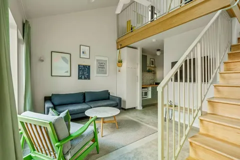 a living room with furniture and a wooden floor