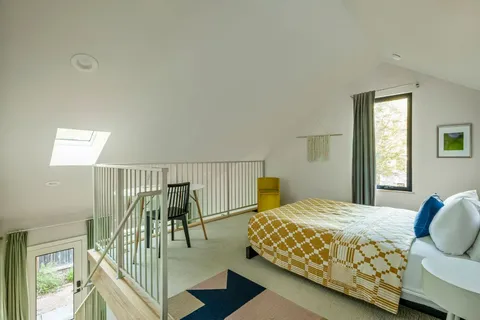 a bedroom with a bed and large windows