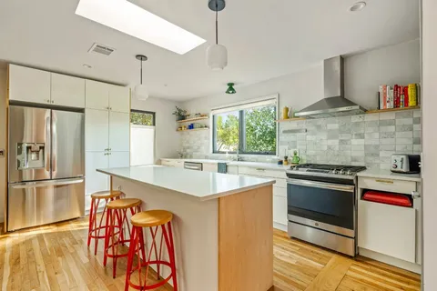 a kitchen with stainless steel appliances granite countertop a stove and a refrigerator