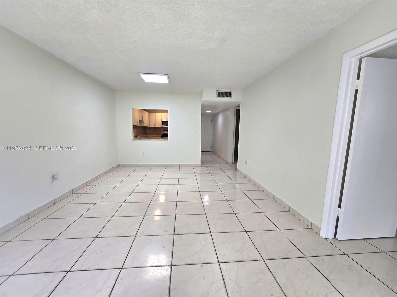 10090 Northwest 80th Court, Unit 1155 Hialeah Gardens, FL 33016 - Photo 10 of 19 a view of a livingroom with an empty space and a window