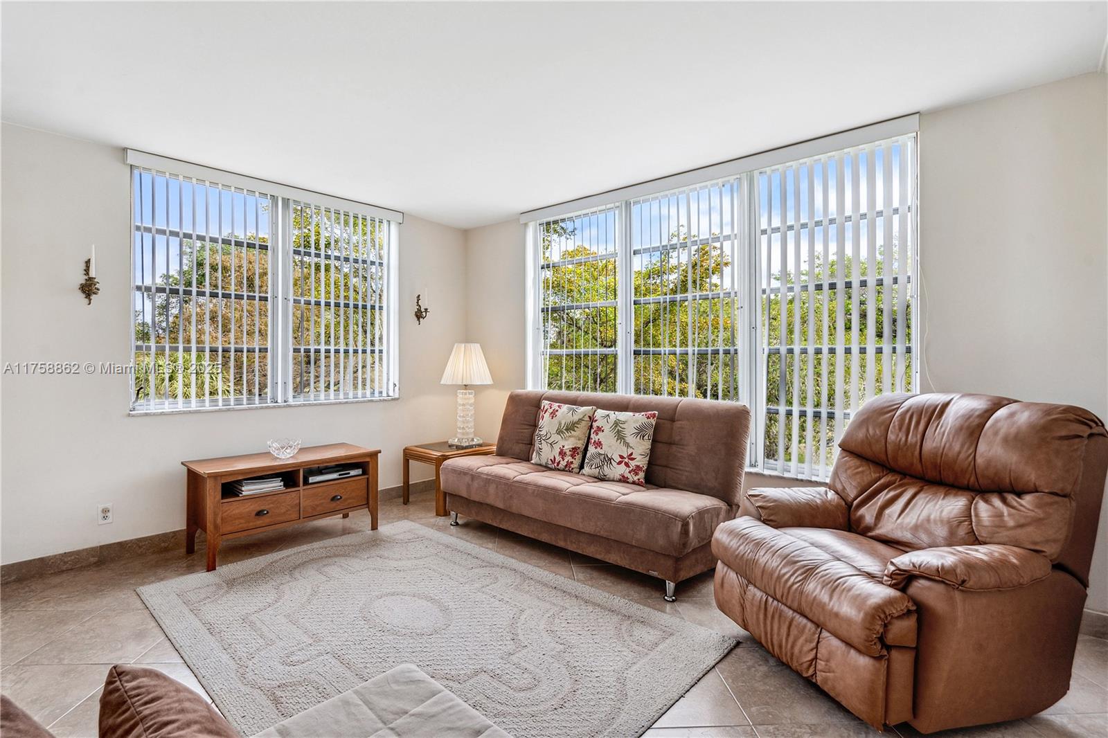 3800 Oaks Clubhouse Drive, Unit 307 Pompano Beach, FL 33069 - Photo 11 of 25 a living room with furniture and a window