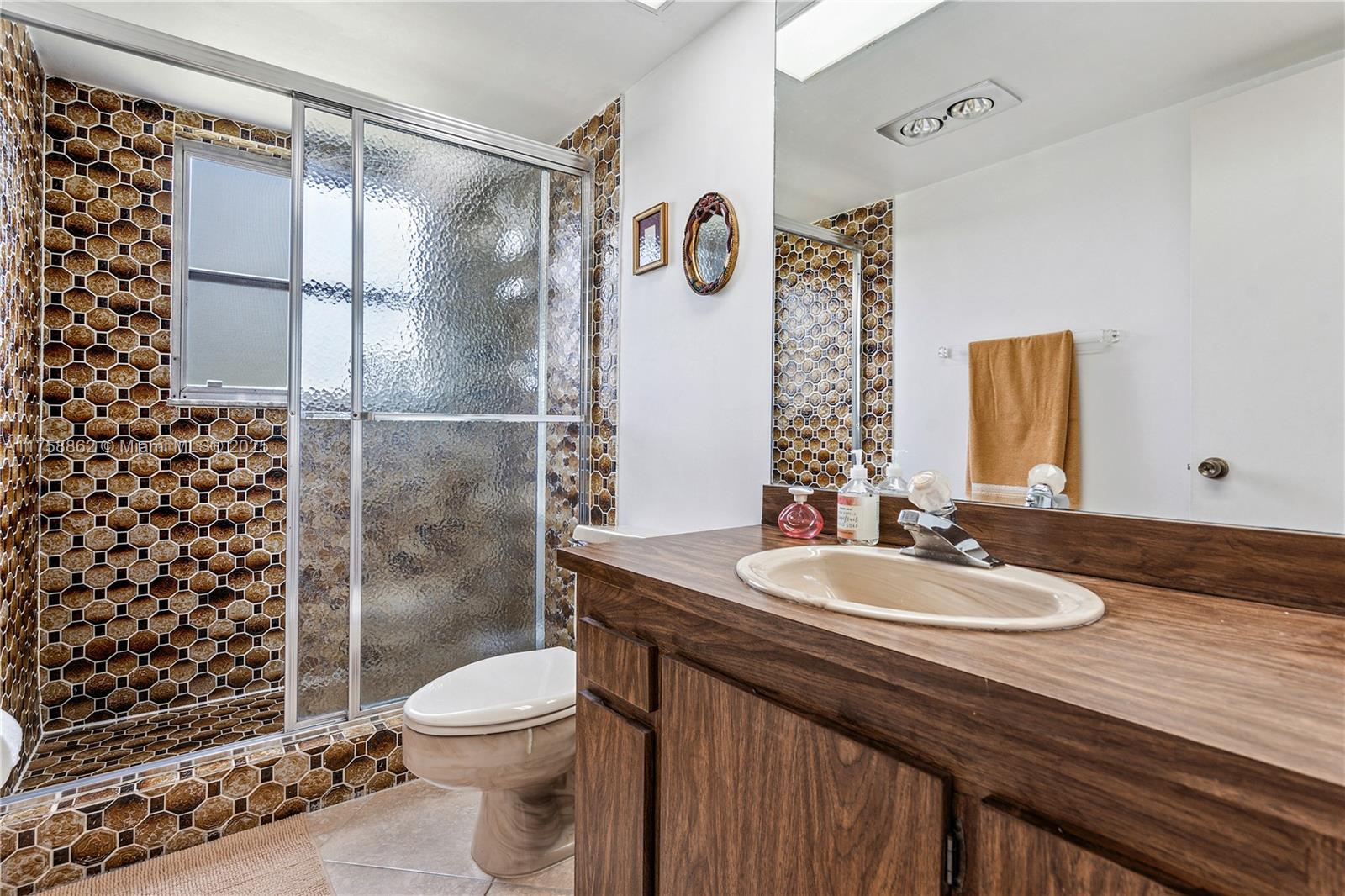 3800 Oaks Clubhouse Drive, Unit 307 Pompano Beach, FL 33069 - Photo 12 of 25 a bathroom with a sink a toilet and shower