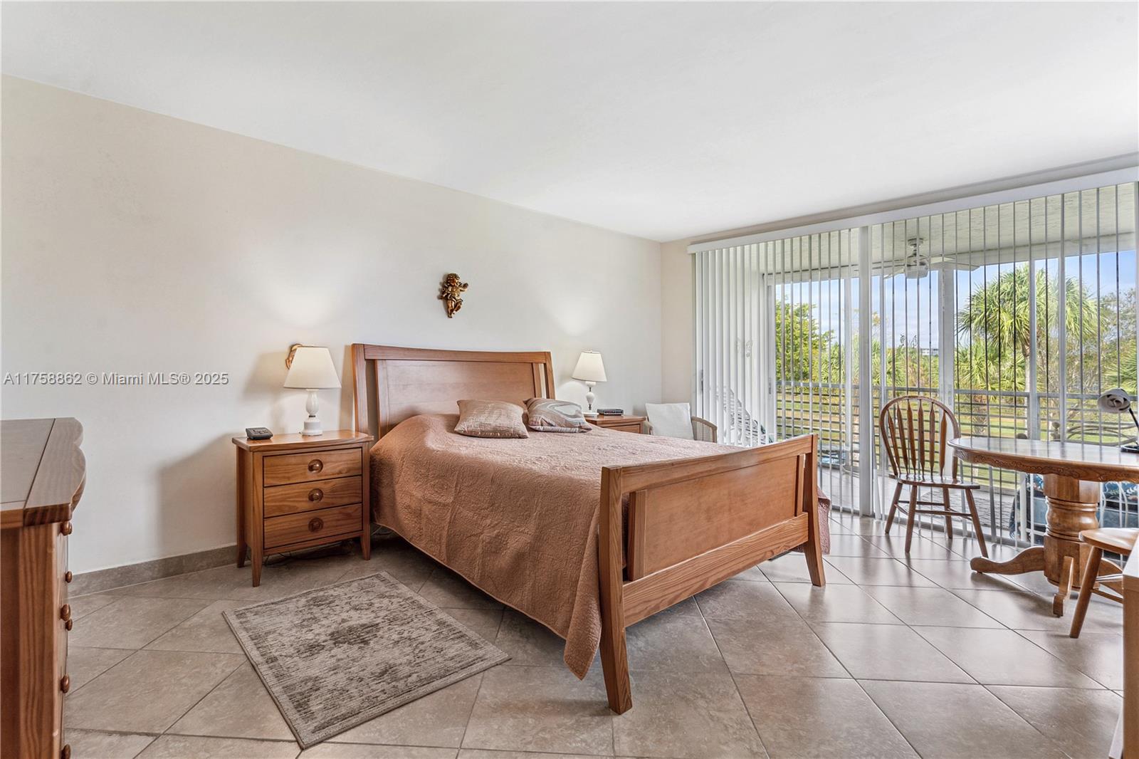 3800 Oaks Clubhouse Drive, Unit 307 Pompano Beach, FL 33069 - Photo 14 of 25 a bed room with a bed and a chair