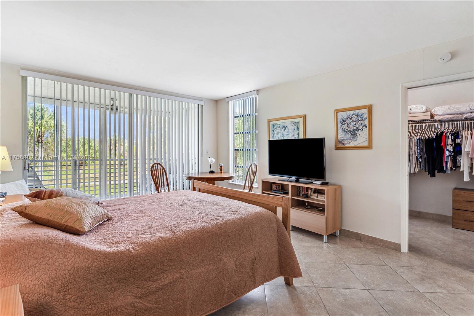 3800 Oaks Clubhouse Drive, Unit 307 Pompano Beach, FL 33069 - Photo 15 of 25 a bedroom with a bed and flat screen tv