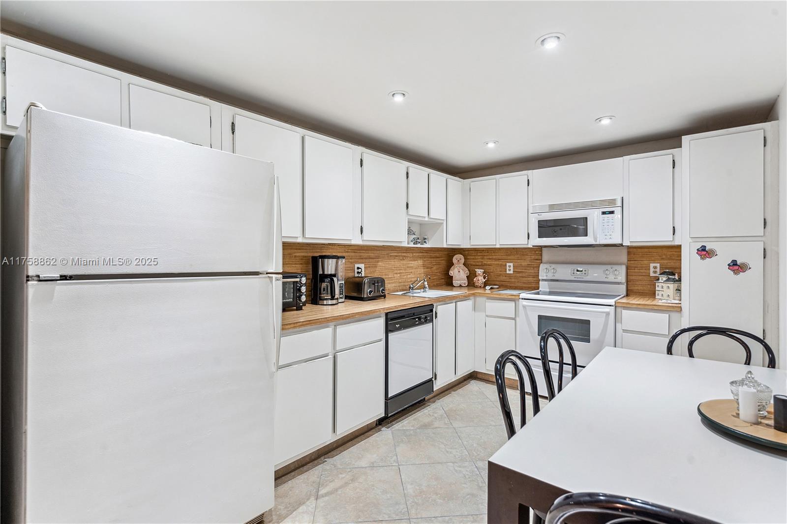 3800 Oaks Clubhouse Drive, Unit 307 Pompano Beach, FL 33069 - Photo 3 of 25 a kitchen with stainless steel appliances granite countertop a refrigerator sink and white cabinets