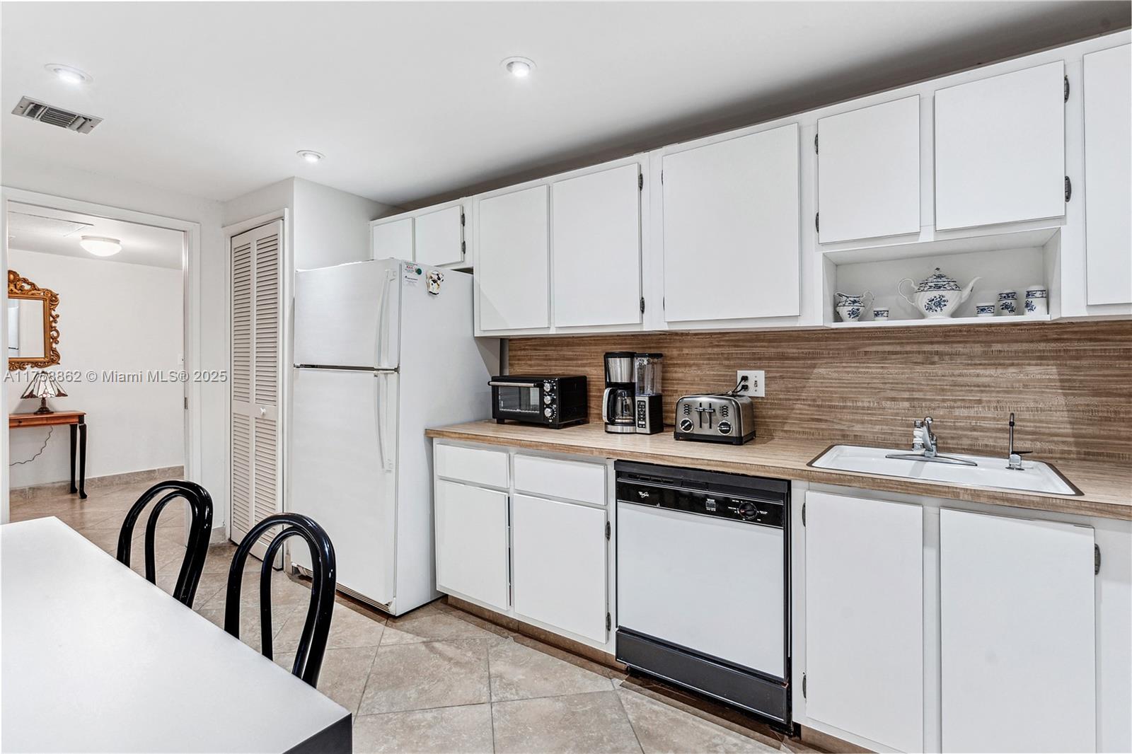 3800 Oaks Clubhouse Drive, Unit 307 Pompano Beach, FL 33069 - Photo 7 of 25 a kitchen with stainless steel appliances granite countertop a stove a sink a refrigerator and white cabinets