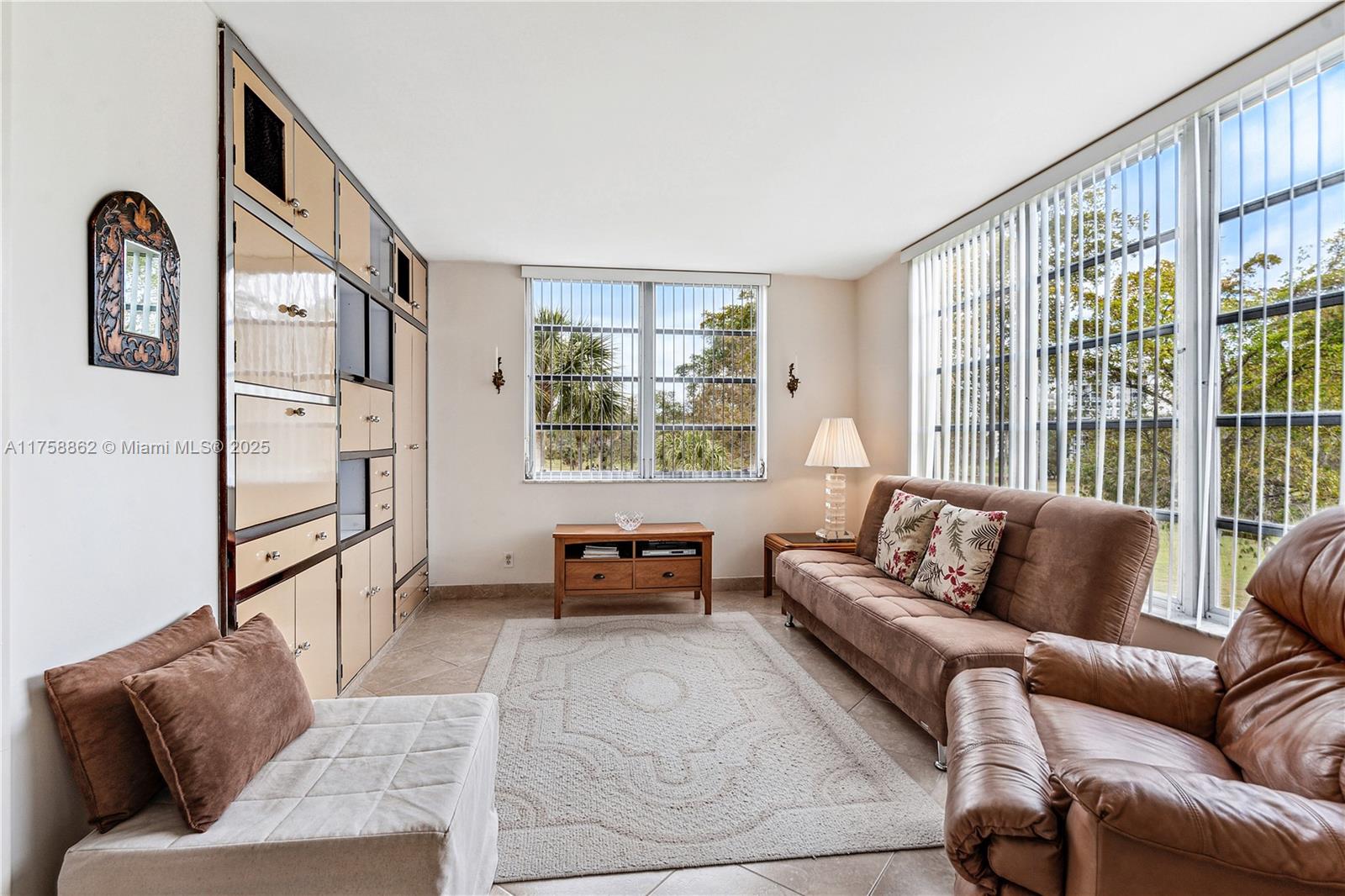 3800 Oaks Clubhouse Drive, Unit 307 Pompano Beach, FL 33069 - Photo 10 of 25 a living room with furniture and a large window