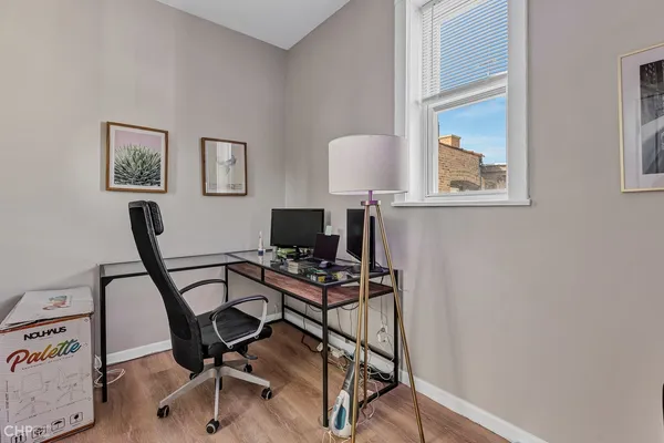 a view of a workspace with furniture and a window