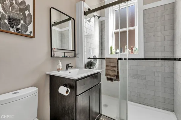 a bathroom with a granite countertop sink a mirror and a shower