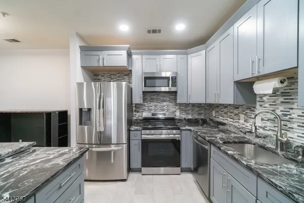 a kitchen with granite countertop stainless steel appliances and wooden cabinets