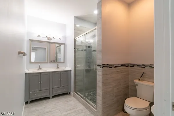 a bathroom with a granite countertop sink toilet and shower