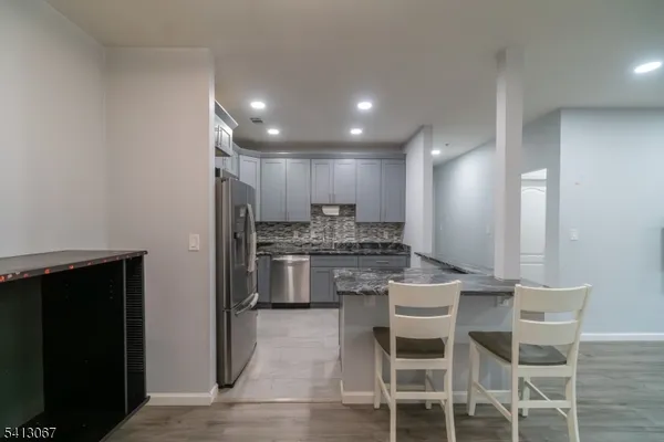 a kitchen with a dining table chairs stainless steel appliances and cabinets