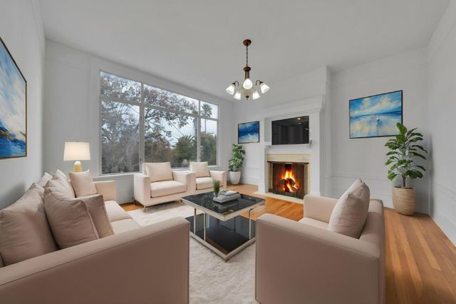 a living room with furniture fireplace and a large window