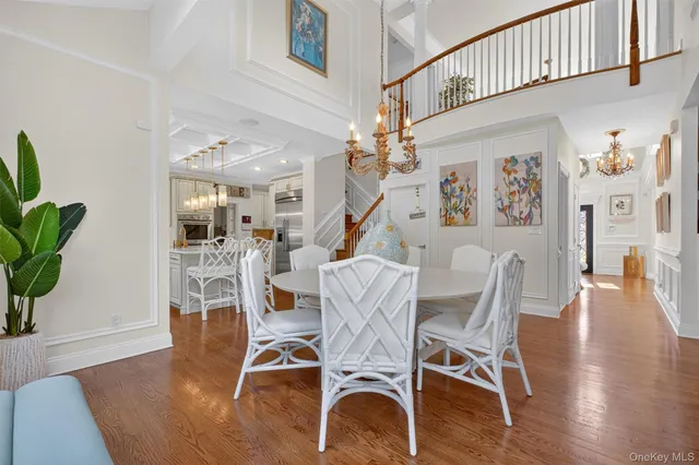 a living room with furniture a chandelier a large window and wooden floor
