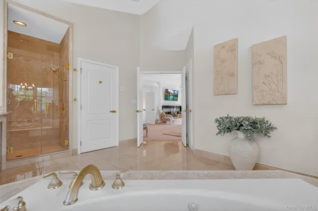 a spacious bathroom with a tub sink and mirror