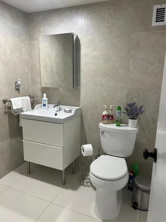 a bathroom with a sink toilet and a mirror