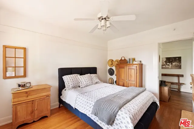 a bedroom with a bed and wooden floor