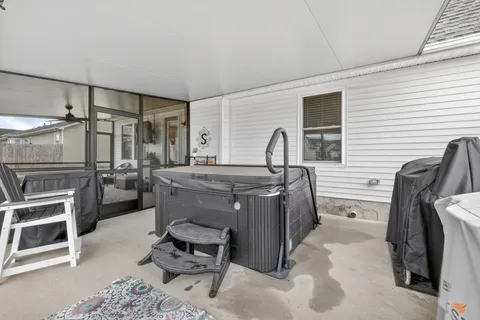 a living room with furniture a flat screen tv and a refrigerator