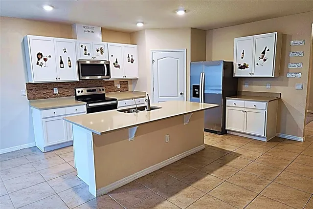 a kitchen with stainless steel appliances a refrigerator stove microwave and sink