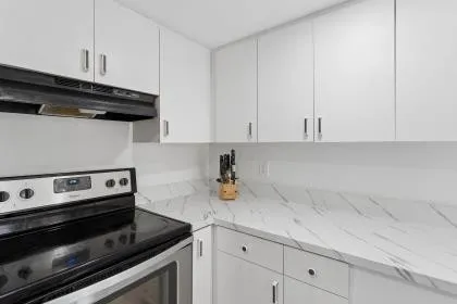 a kitchen with a stove and white cabinets