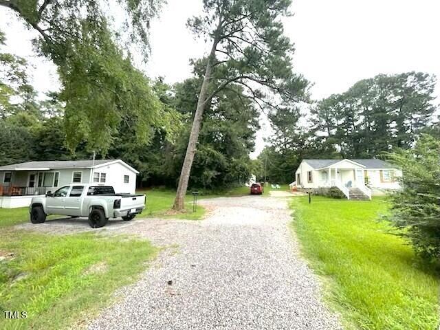 a front view of a house with a garden and trees